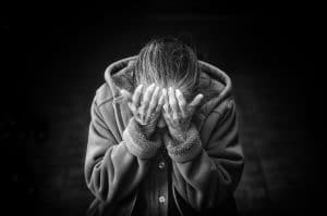 black and white picture of Elderly woman with hands on her face, upset